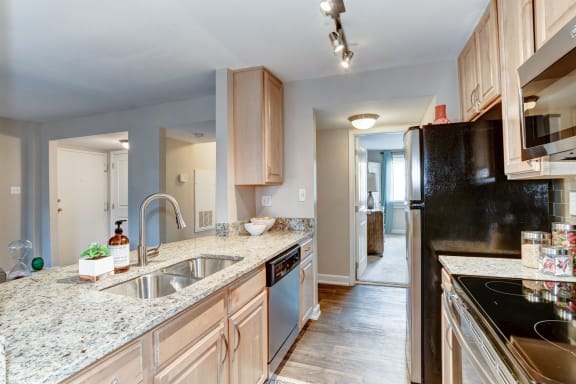 a kitchen with wood cabinets and granite countertops at Ellicott Grove, Maryland