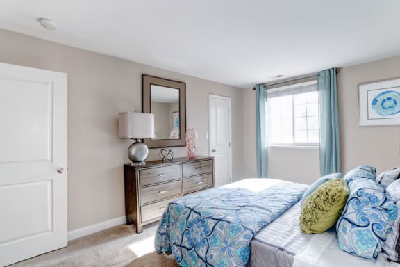 a bedroom with a bed and a dresser with a mirror at Ellicott Grove, Ellicott City Maryland