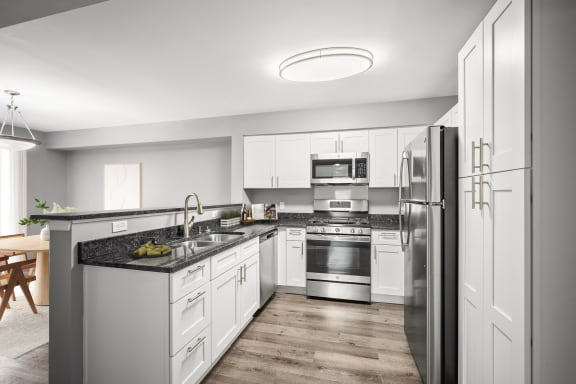 a kitchen with white cabinets and stainless steel appliances at Villages at Morgan Metro, Landover, MD