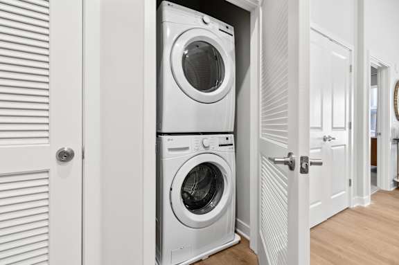 A white washing machine is in a white door.