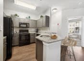 A kitchen with a refrigerator, oven, and sink.