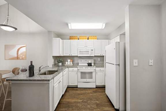 A kitchen with white cabinets and appliances.