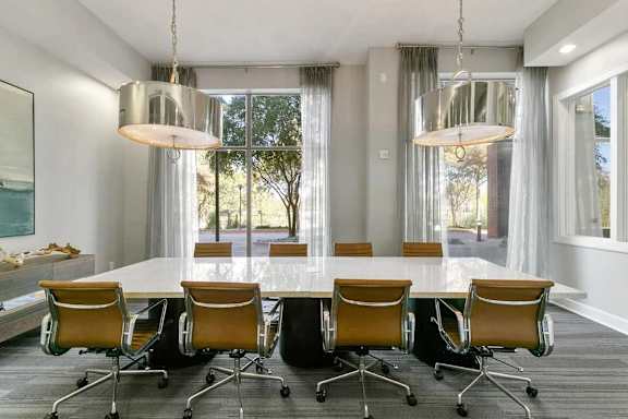 A conference room with a long table and chairs.