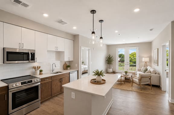 A modern kitchen with a large island and a view of the backyard.