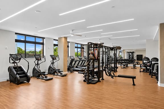 A gym with a variety of equipment including treadmills, weights, and exercise machines.