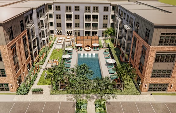 A large courtyard surrounded by buildings with a pool in the middle.