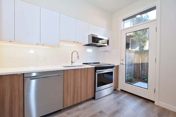 A kitchen with white cabinets and a stainless steel dishwasher.