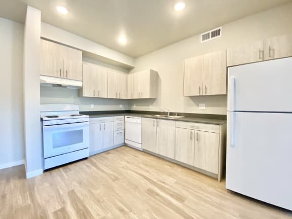 2 bed 2 bath kitchen with stove, range hood, and refrigerator