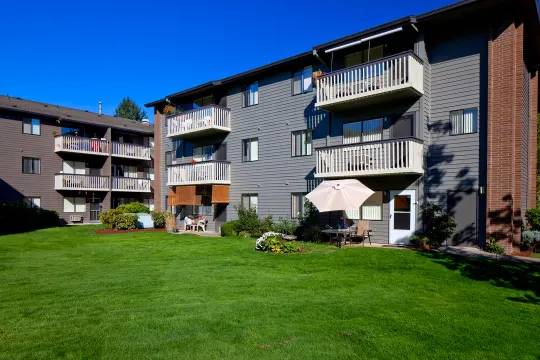 A sunny day at a residential apartment complex with green lawns and balconies.
