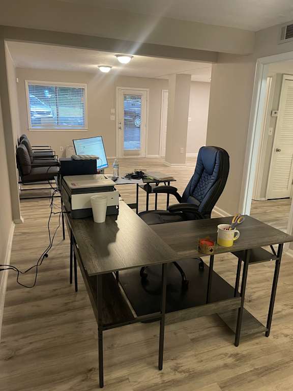 A room with a desk, chair, and laptop.