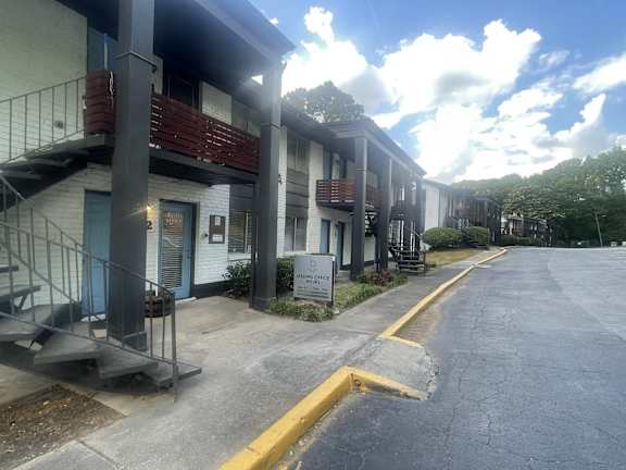 A row of apartment buildings with a blue sky and clouds in the background.