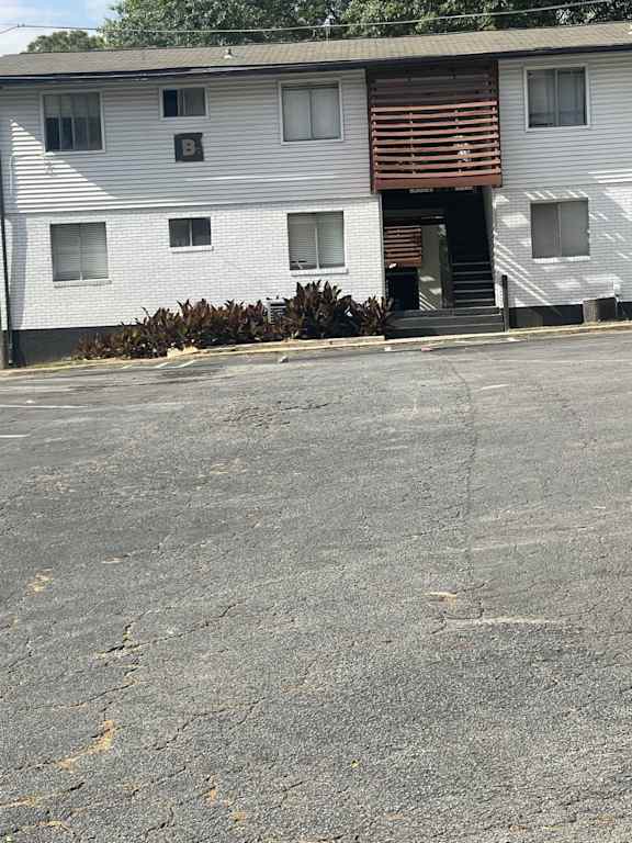 A white building with a brown door and windows.