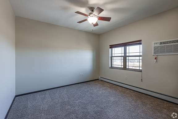 an empty living room with a window and a door