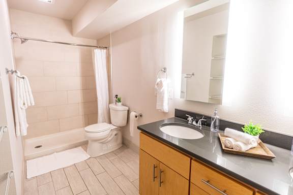 A bathroom with a white toilet, a sink, and a bathtub with a shower curtain.