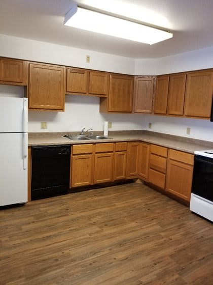 A kitchen with wooden cabinets and a white refrigerator.