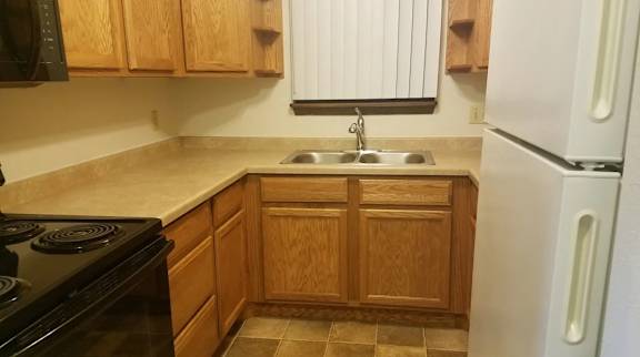 A kitchen with wooden cabinets and a black stove top oven.