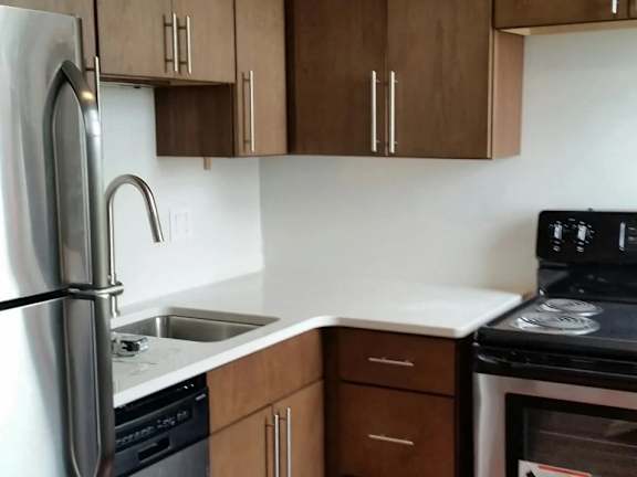 A kitchen with brown cabinets and a black stove top.