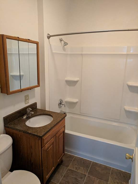A bathroom with a toilet, sink, and bathtub.