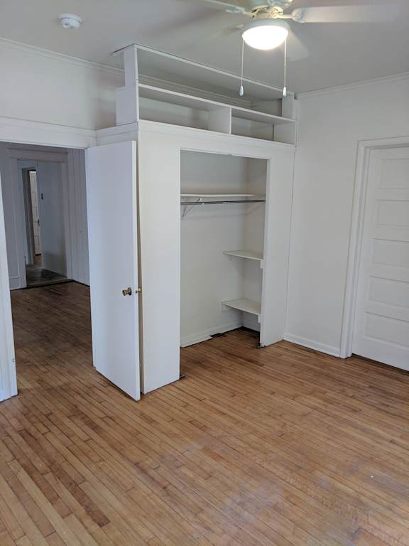 A room with a white cabinet and a wooden floor.