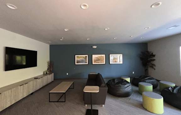 A living room with a grey carpet and a wooden floor.