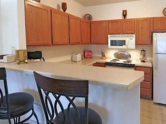 A kitchen with wooden cabinets and a white countertop.