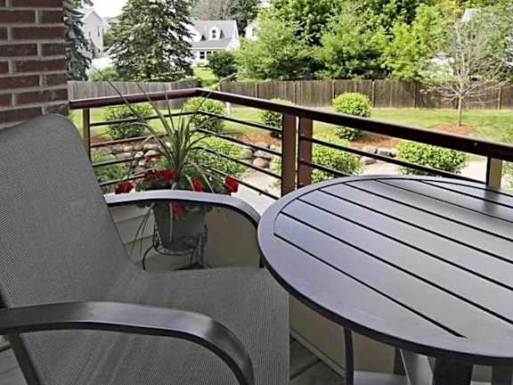 A patio with a table and chairs overlooking a yard.
