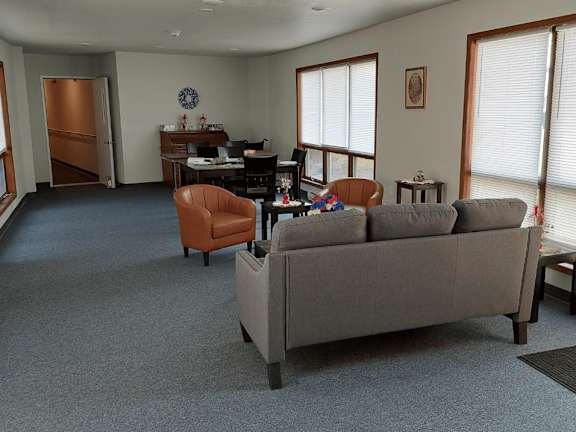 A living room with a grey couch and a brown chair.
