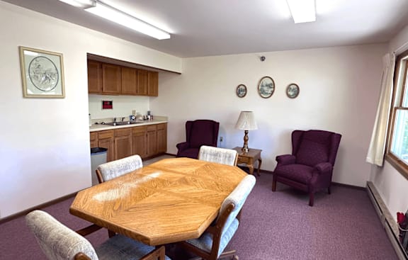 A dining room with a wooden table and chairs.
