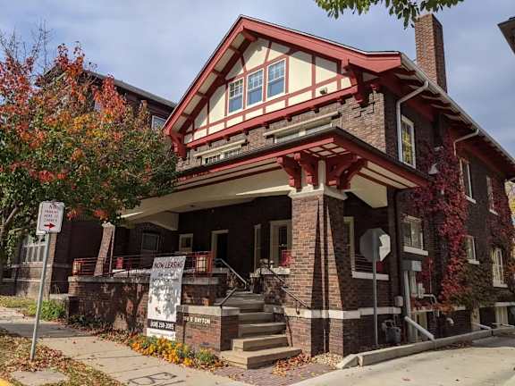 A house with a red roof and a sign that says "No Parking".