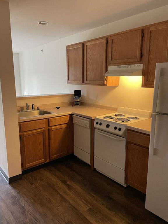 a kitchen with white appliances and wooden cabinets