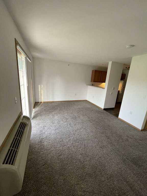an empty living room with a heater in the corner