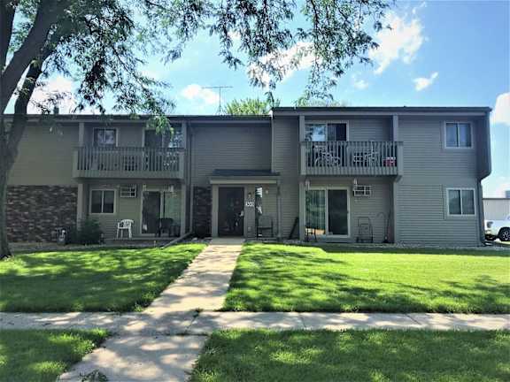 A sunny day at the apartment complex with green lawns and trees.