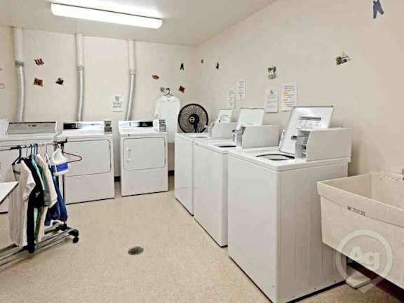 A laundry room with washers and dryers.