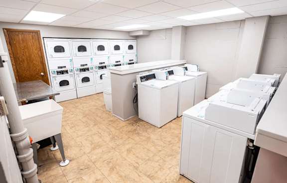 A room with white appliances and a brown door.
