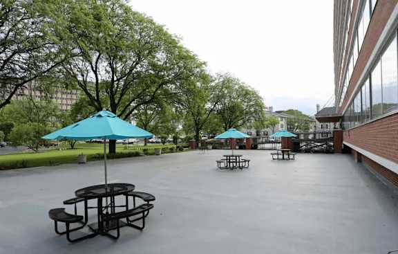 A park with tables and umbrellas is empty.