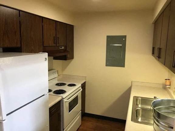 A kitchen with a white refrigerator, stove, and oven.