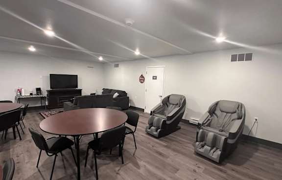 A room with a table, chairs, and a television.