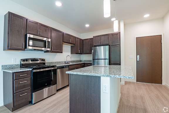A kitchen with brown cabinets and stainless steel appliances.