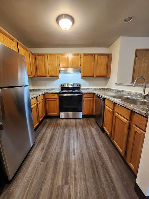 a kitchen with wood cabinets and stainless steel appliances