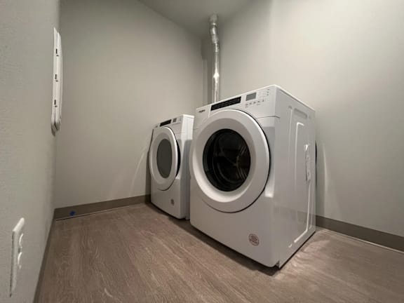 Two front loading washing machines in a laundry room.