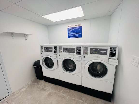 A row of washing machines in a laundry room.