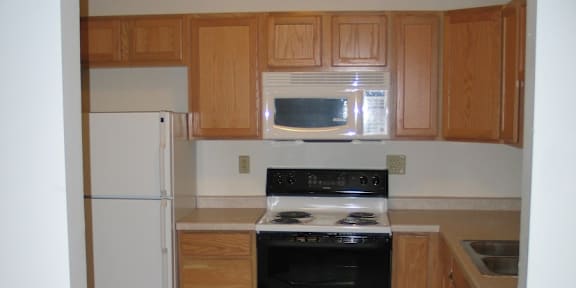 A kitchen with wooden cabinets and a black stove top oven.
