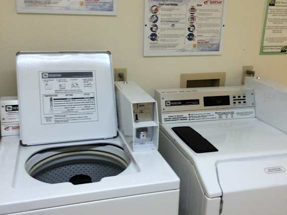 A washing machine with a door open and a dryer to the right.