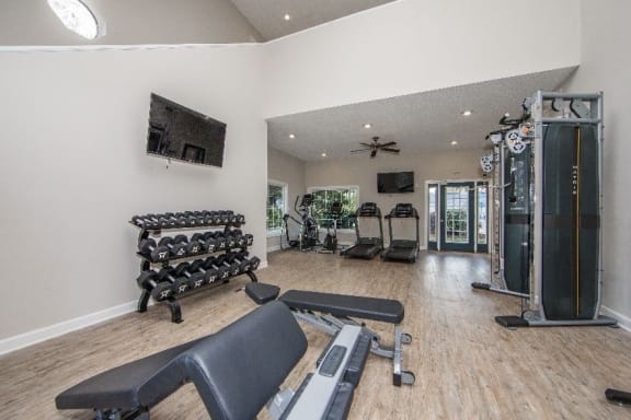 a workout room with weights and cardio equipment in a home gym