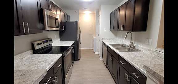 A kitchen with black cabinets and granite countertops.