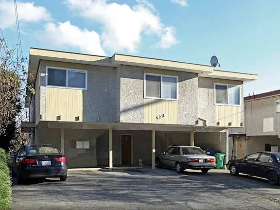 A two-story building with a garage and a car parked in front.