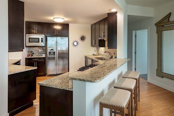 A kitchen with a granite countertop and stainless steel appliances.