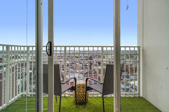 A balcony with two chairs and a table.