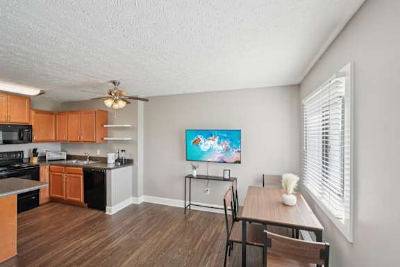 A kitchen with a dining table and chairs.