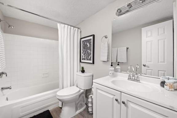 A white bathroom with a toilet, sink, and bathtub.